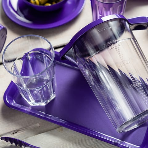 A clear American style tumbler on a purple serving platter.